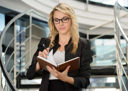 Portrait of a cute young business woman smiling, in an officeの写真素材