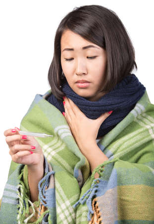 Young asian woman is holding thermometer in hand. She has temperature.の写真素材
