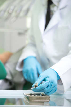 Hands of dentist and dental tools and syringe at dentist's surgery.の写真素材