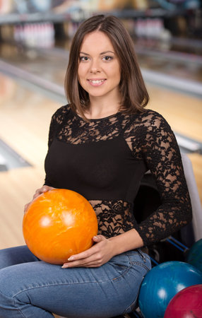 Portrait of a young smiling woman at the colored layers in bowling club.の写真素材
