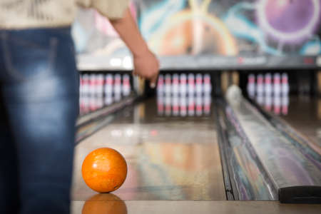 Woman in club for bowling is throwing ball.の写真素材