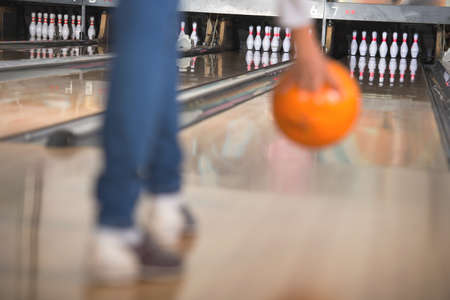 Young woman in club for bowling is throwing ball.の写真素材