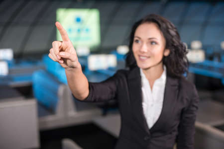 Portrait of a smiling young woman is standing in the background of the modern conference hall.の写真素材