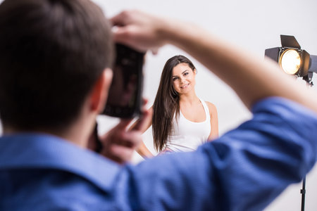 Photographer at work with model in the professionally equipped studio.