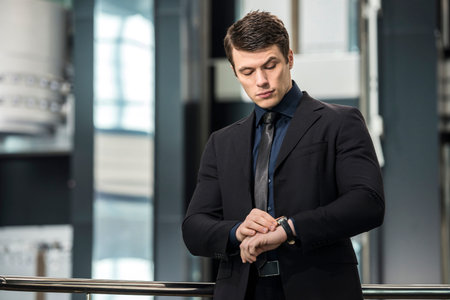 Handsome young businessman Watching on his watch in modern office.の写真素材