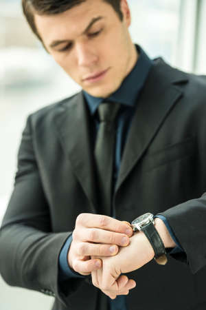 Handsome young businessman standing in modern office.の写真素材