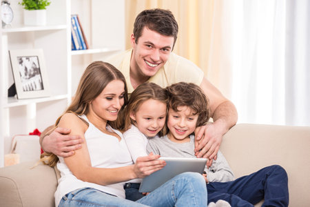 Happy to be a family. Portrait of happy family with kids on the couch.の写真素材