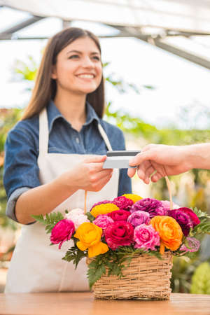 Close-up. Customer giving credit card to the seller florist.の写真素材