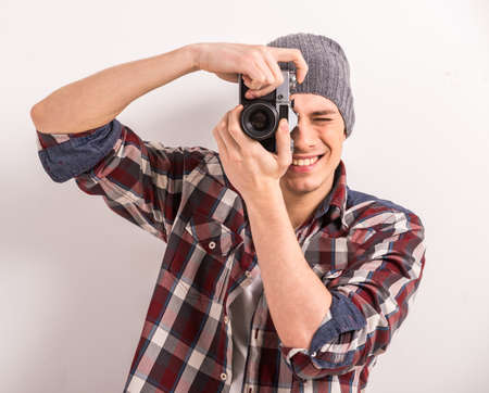 Young man is taking a picture with an old camera.の写真素材