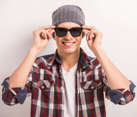 Young stylish man in black glasses and casual clothes over gray background.の写真素材