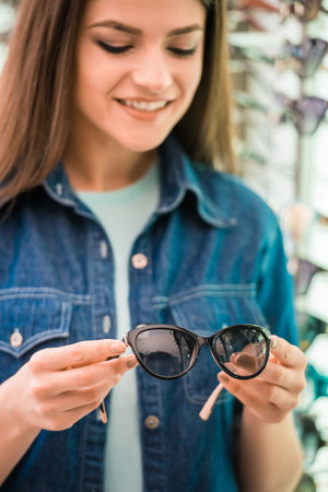 Portrait of happy female customer buying a new glasses at optician store.の写真素材