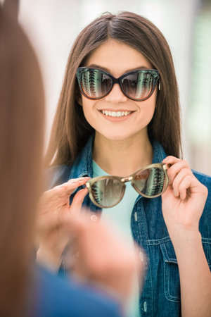 Happy female customer buying a new glasses at optician store.の写真素材