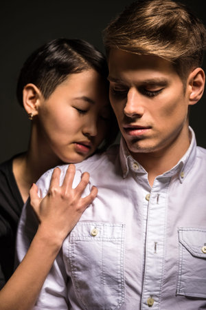 Young fashionable passionate couple dressed casual posing in the studio. Fashion portrait.