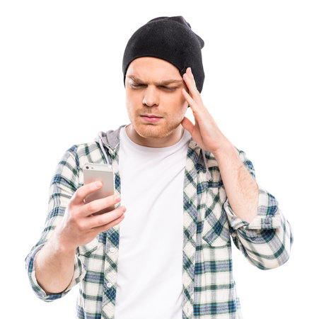 Man dressed casual looking at phone. Bad news. Studio shot.