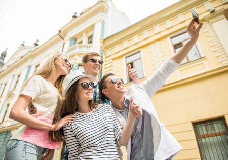Double couple date. Friends walking down the street together and making selfie.の写真素材