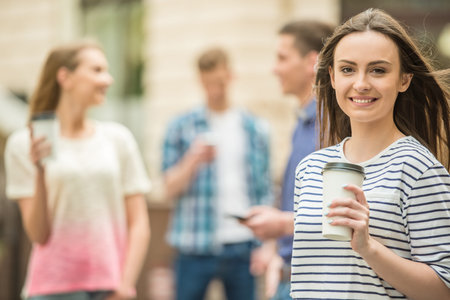 Four friends having fun outdoors and drinking coffee. Double couple date.の写真素材