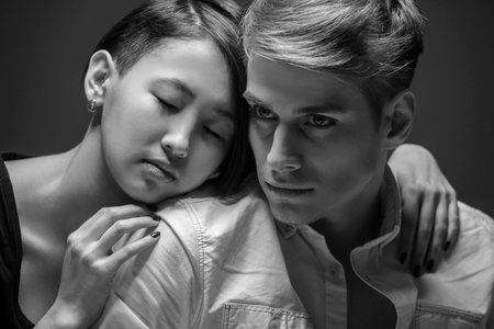 Young fashionable couple posing in the studio. Woman hugging man. Black and white fashion portrait. Tenderness.の写真素材