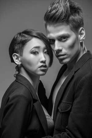 Young fashionable couple in tuxedos  posing in the studio. Black and white fashion portrait. Passion.の写真素材
