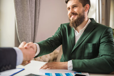 Two confident businessmen discuss contract at business meeting and shaking hands.の写真素材