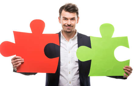 Handsome man in suit holding big puzzles. White background.の写真素材