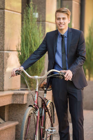 Businessman in suit going to work on his bicycle. Healthy lifestyle concept.の写真素材
