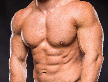Muscular male body on black background studio shoot.