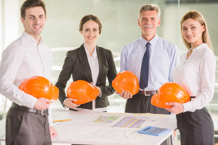 Four charismatic architects looking at plans together around a table.の写真素材