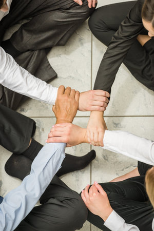 Business team relaxing on the floor at the office. Close-up.