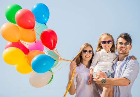 Happy family with balloons outdoor on a summer day. Sky background.の写真素材
