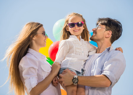 Happy family playing with balloons at the day time. Friendly family concept.の写真素材