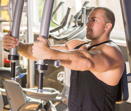 Male bodybuilder doing heavy weight exercise for chest.