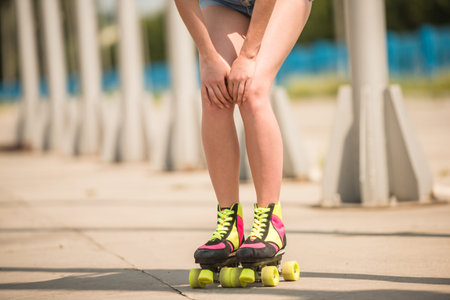 Close-up of female legs in roller skates outdoors. Front view.