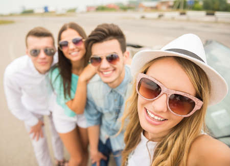 Two beautiful couples near cabriolet looking at camera and smiling.の写真素材