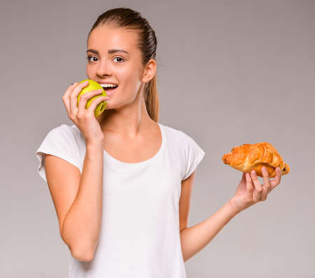Difficult choice between junk and healthy food. Fruits or sweets.の写真素材