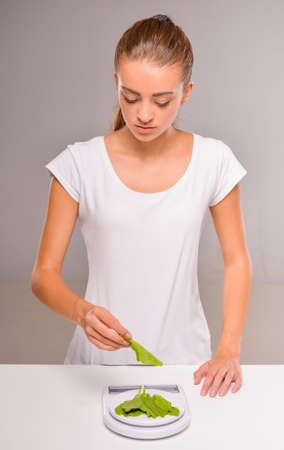 Young woman weighs herbs. Concept of healthy food.の写真素材