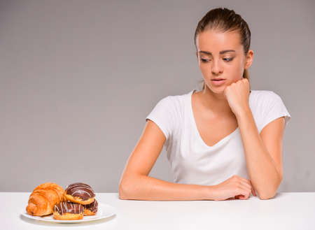 Young woman with plate of sweets. Concept of diet. Healthy food.の写真素材