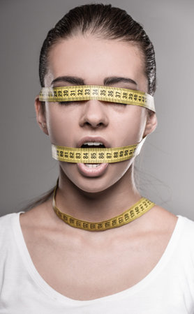 Health care healthy lifestyle. Sport fit fitness woman with a colorful measure tape around her head.