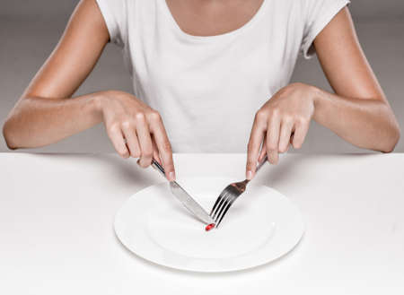 Woman is eating a pill. Concept of healthy food, diet.の写真素材