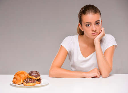 Young woman with plate of sweets. Concept of diet. Healthy food.の写真素材