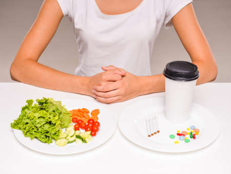 Difficult choice between healthy food and drugs.の写真素材