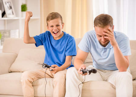 Father and son spend time together, are playing game.の写真素材