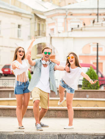 Friendship, leisure and people concept. Young people having fun together, outdoors, in the town.の写真素材