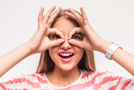 Portrait of young girl is having fun on white background.の写真素材
