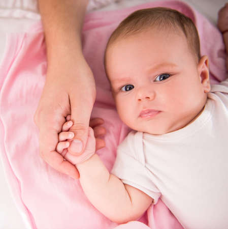 Portrait of a happy baby lying on the bed at homeの写真素材