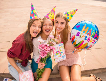 Three beautiful young women celebrating a birthday, outdoorsの写真素材