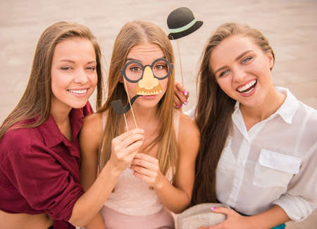 Three beautiful young women celebrating a birthday, outdoorsの写真素材