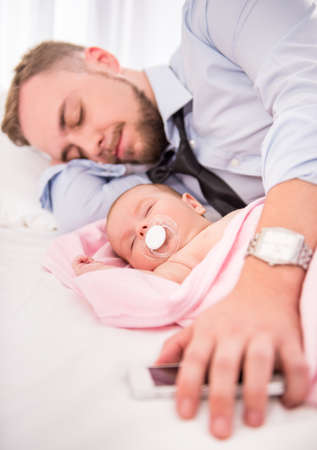 Portrait of young happy father with a baby at homeの写真素材