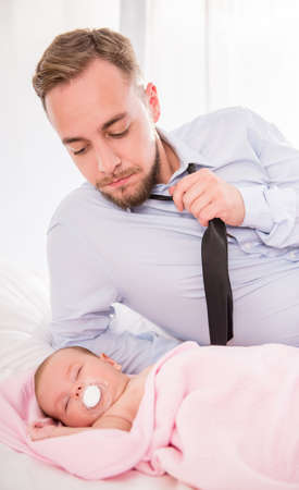 Portrait of young happy father with a baby at homeの写真素材