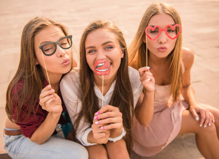 Three beautiful young women celebrating a birthday, outdoorsの写真素材