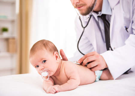 Portrait of a young doctor reviews the babyの写真素材